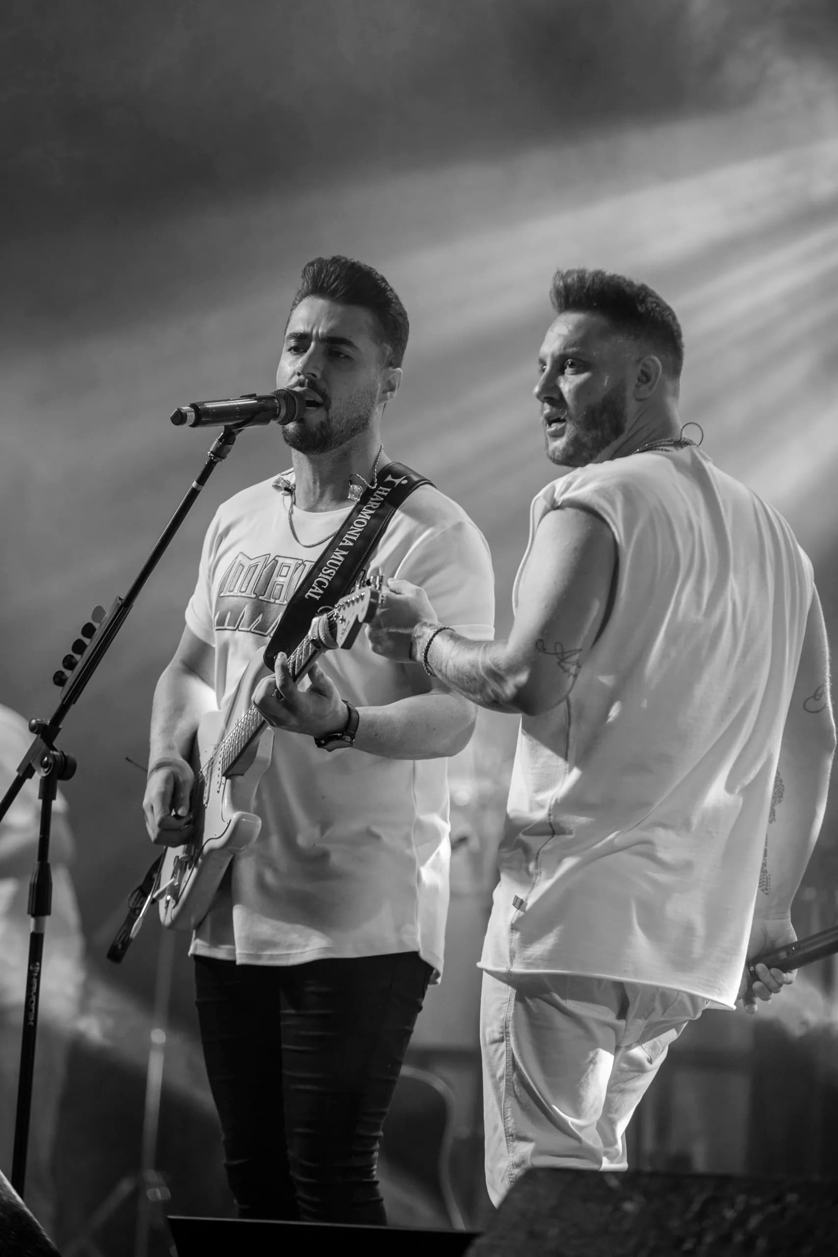 Bruno e Denner cantando juntos em fotografia preto e branco